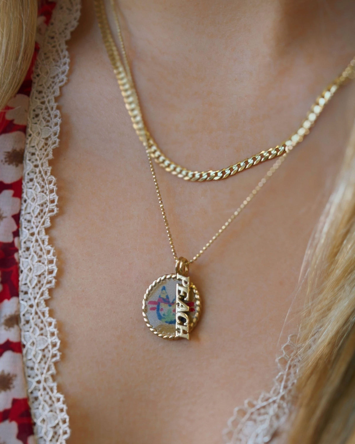 3mm Faceted Cuban Chain layered with a locket pendant over a lace-trimmed top.