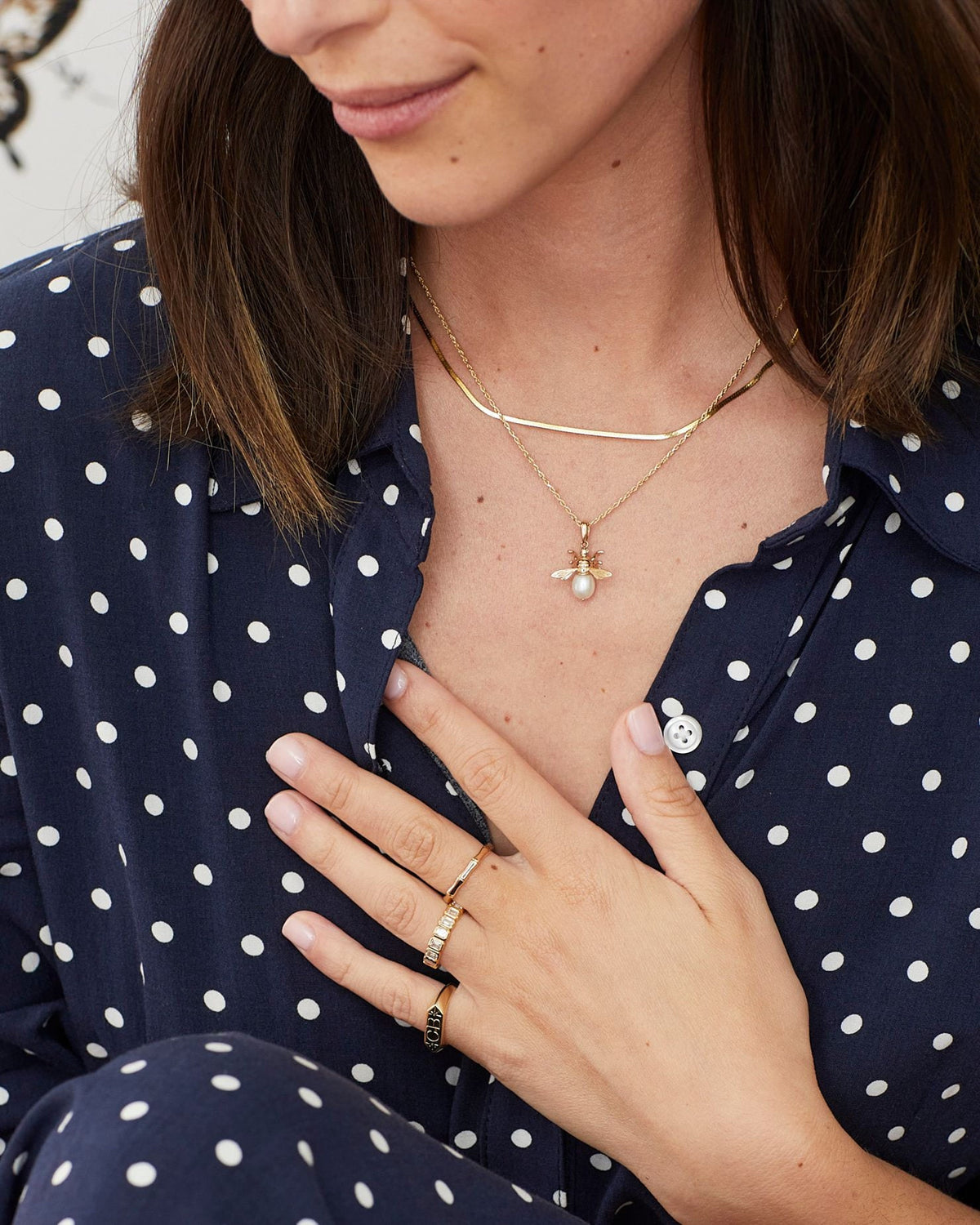 1.2mm Singapore Chain with a pendant, hand at the collar of a navy polka dot shirt.