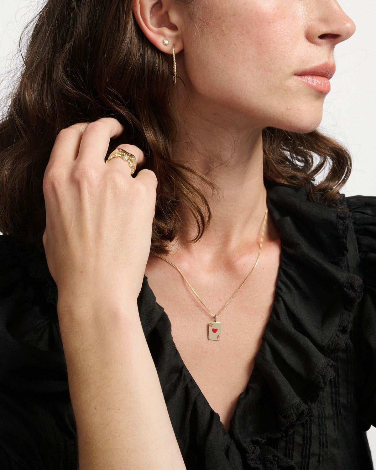 Diamond Twine Stud on a model with dark wavy hair in a black ruffled blouse, a hand raised to her hair.