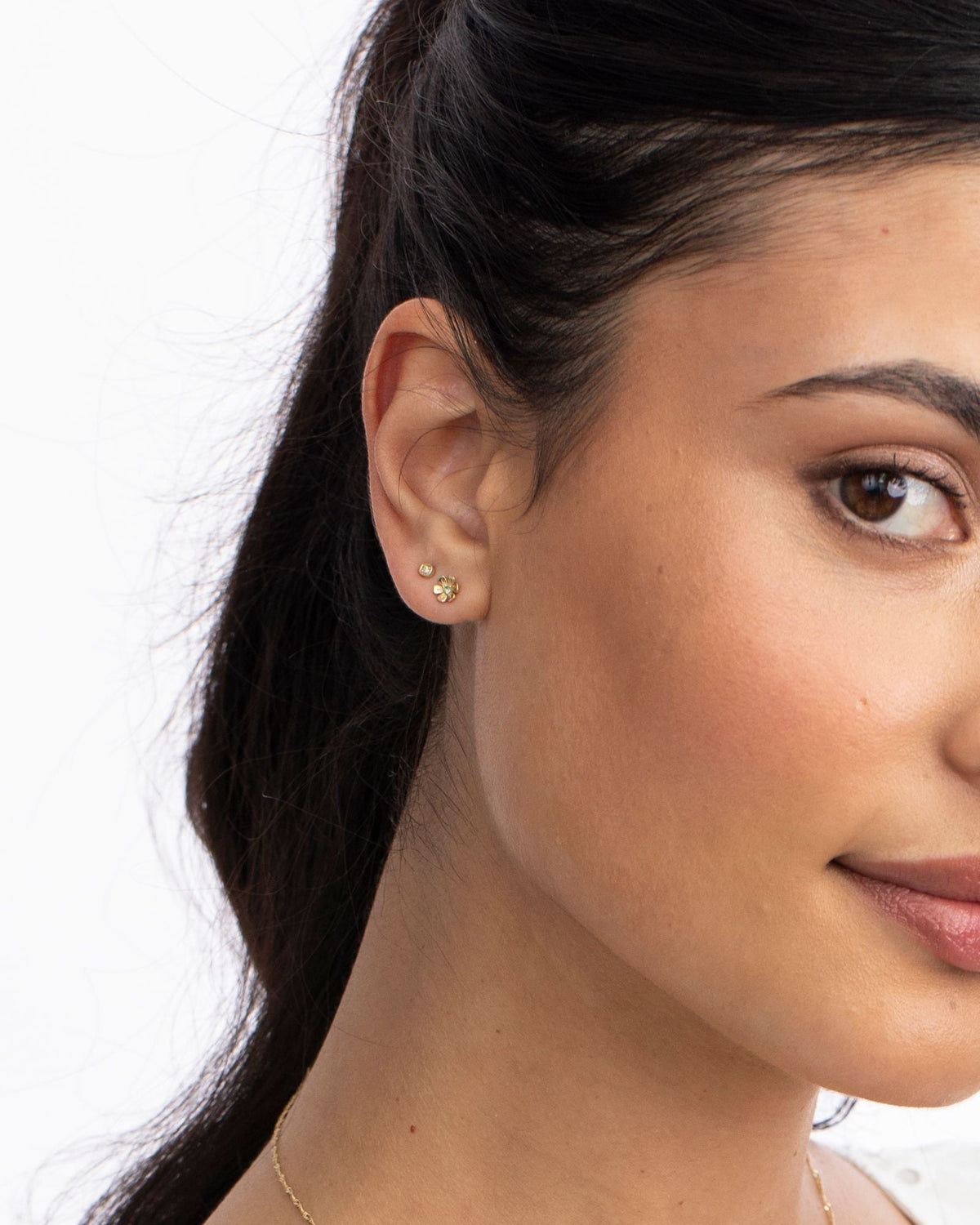 Close-up of an In Bloom Birthstone Stud on the ear, white background.