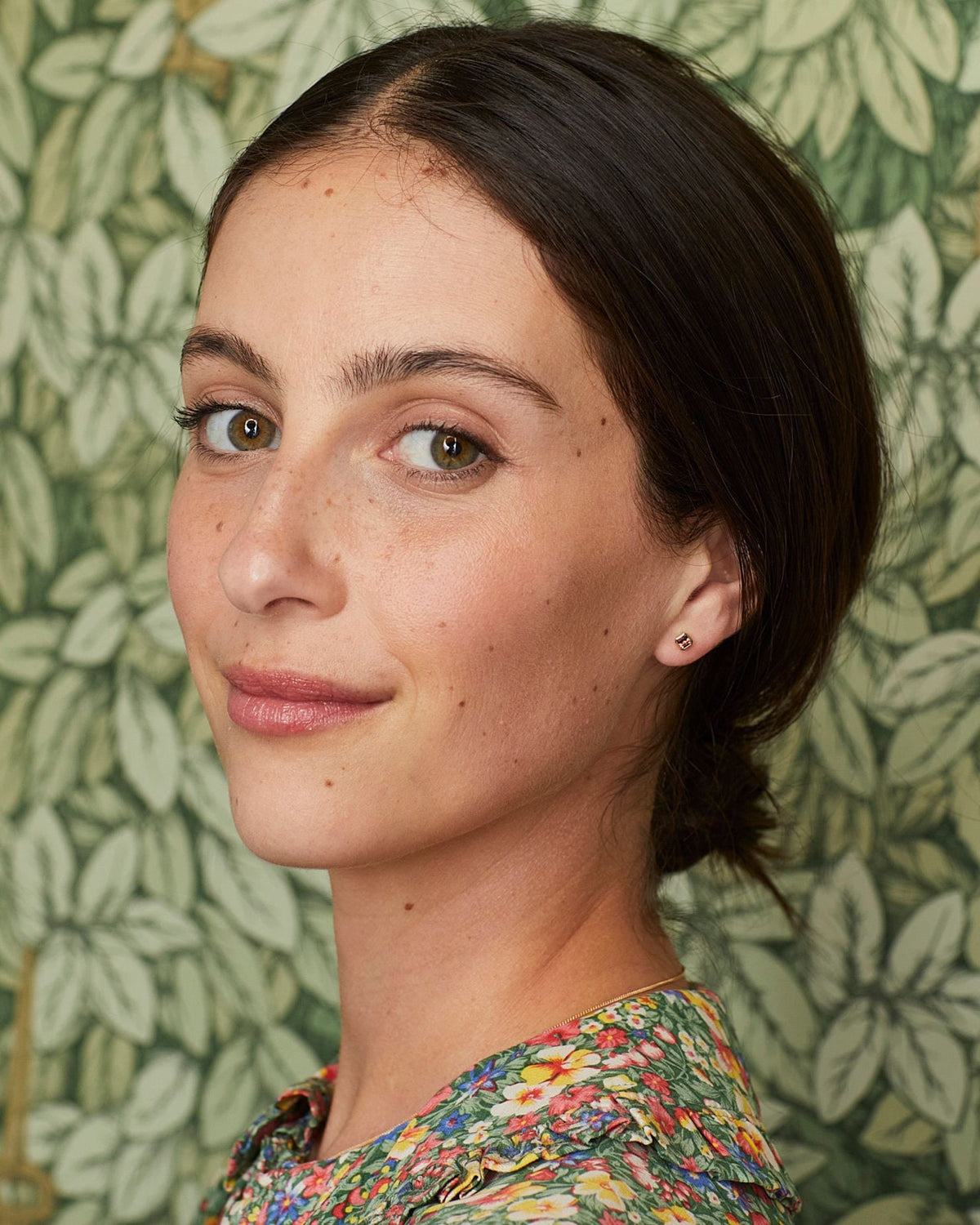 Petite Dahlia Asscher Stud worn with a floral blouse against leaf wallpaper.