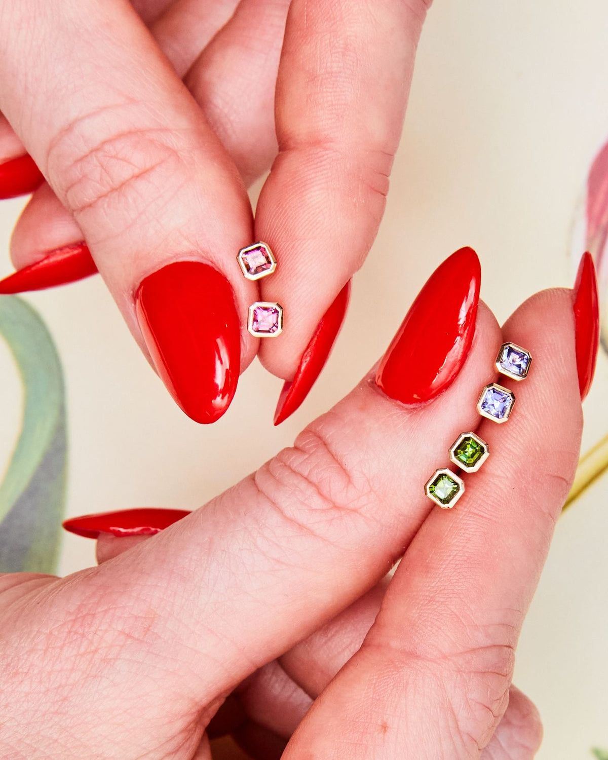 Fingertips with Petite Asscher Studs in dahlia pink and other stones.
