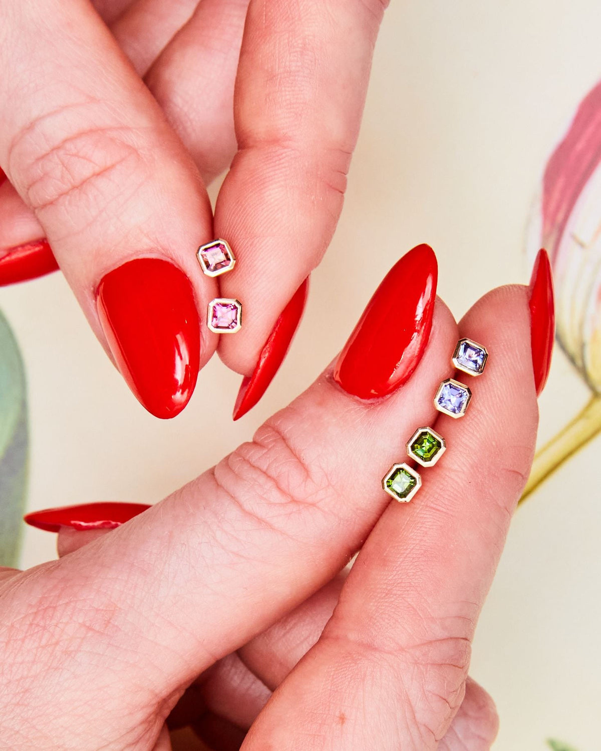Fingertips with Petite Asscher Studs in fern green and other stones.