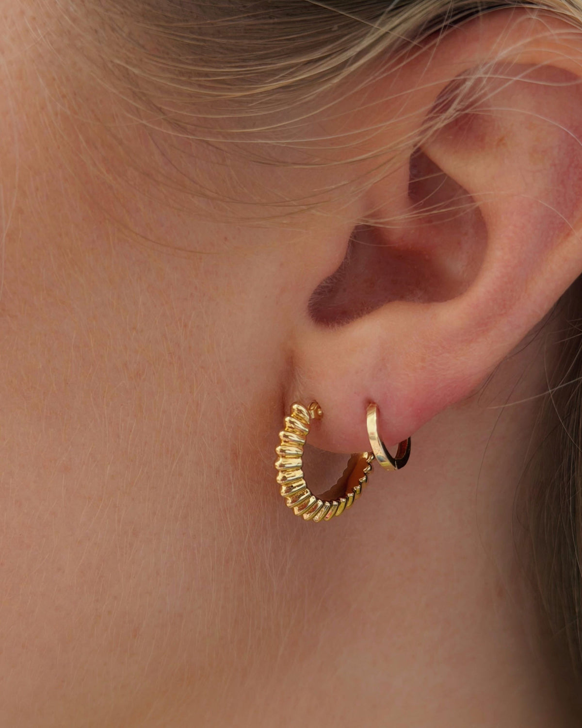 Ridged Knife Edge Helium Hoop on the ear beside a petite hoop.