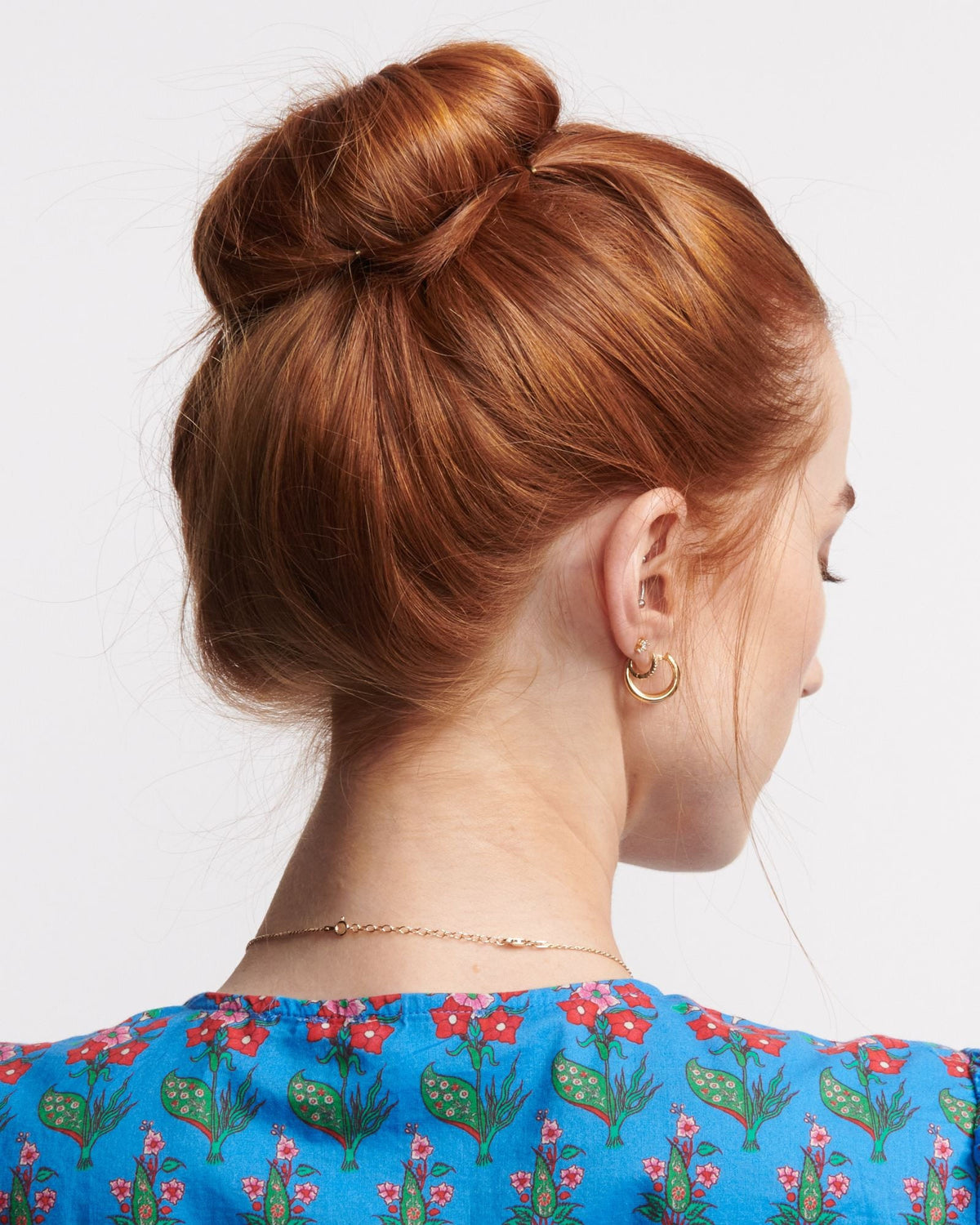 Chain Extender at the nape of the neck, worn with a blue floral top and an updo.