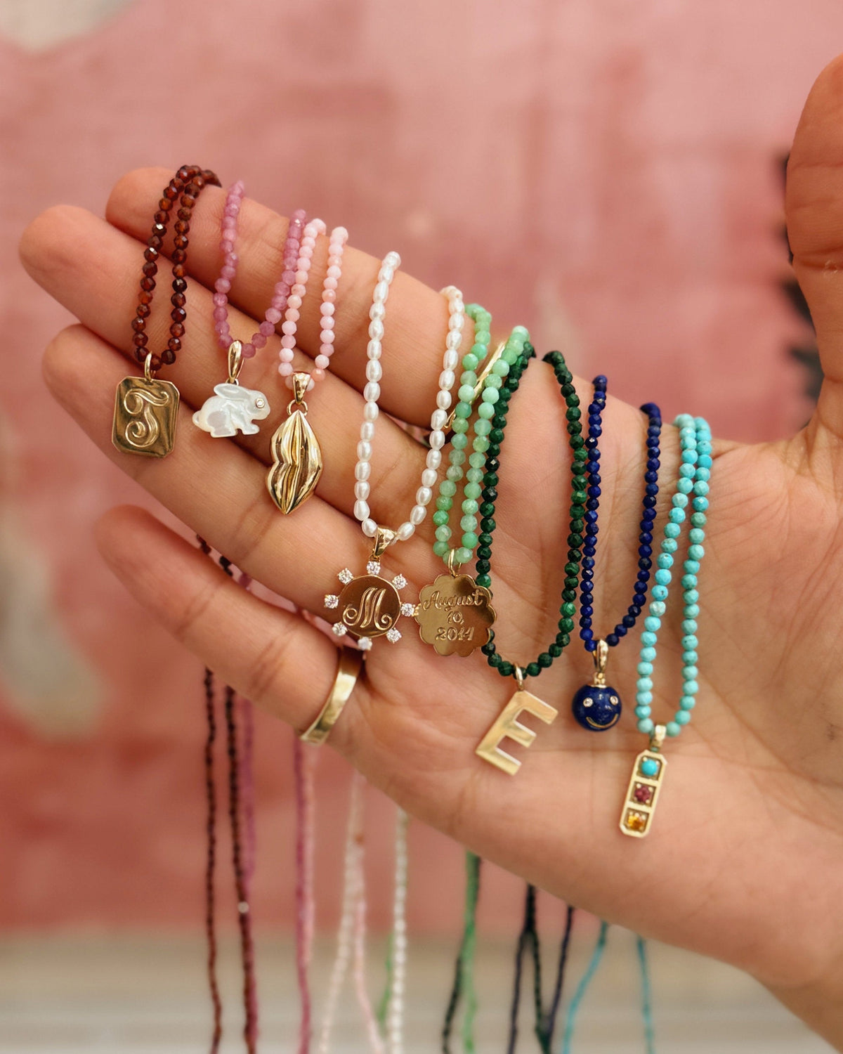 charm and beaded necklaces lined up on a hand