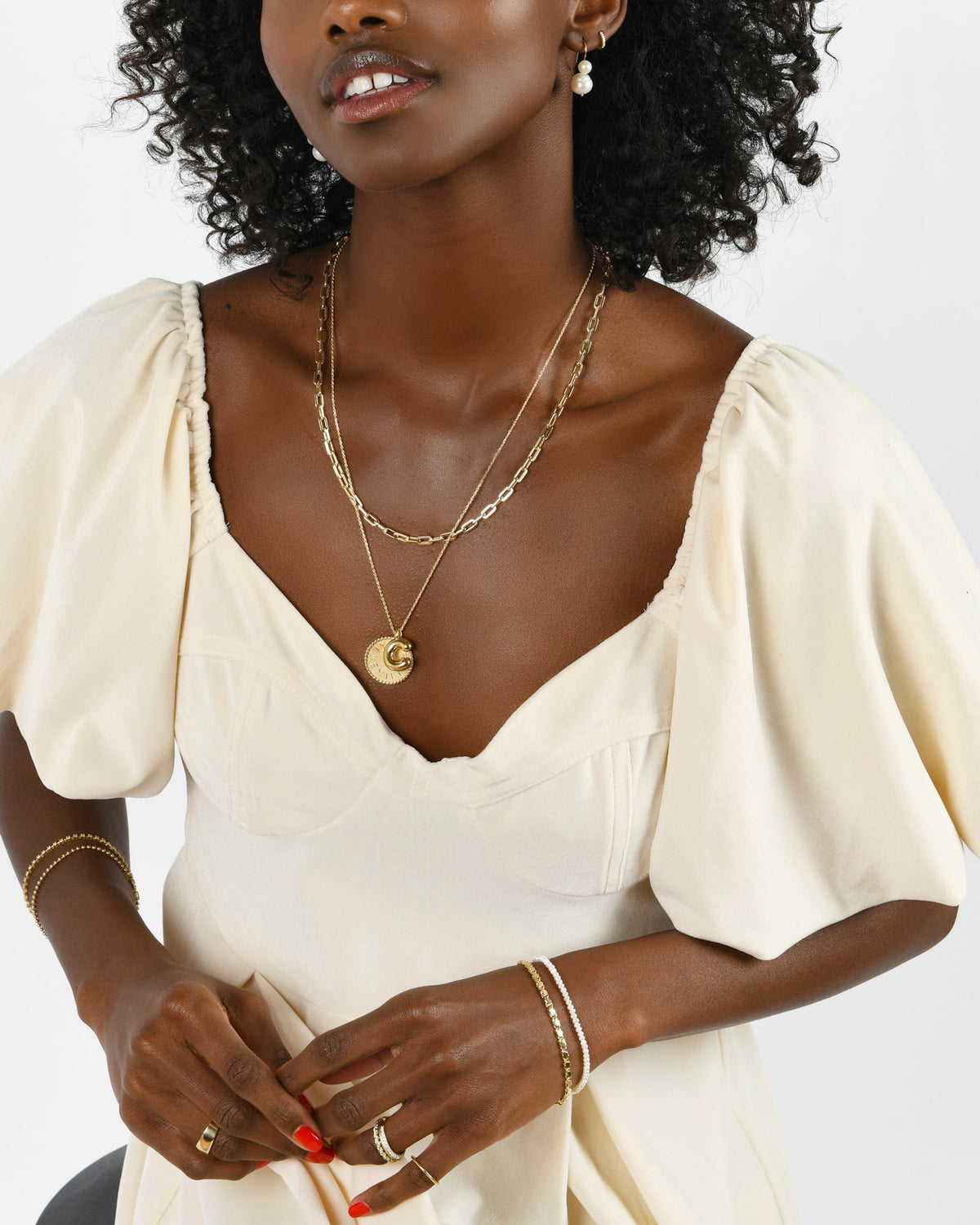 Model wearing Imperial Disc Pendant layered with an initial charm and a Classic Link Necklace
