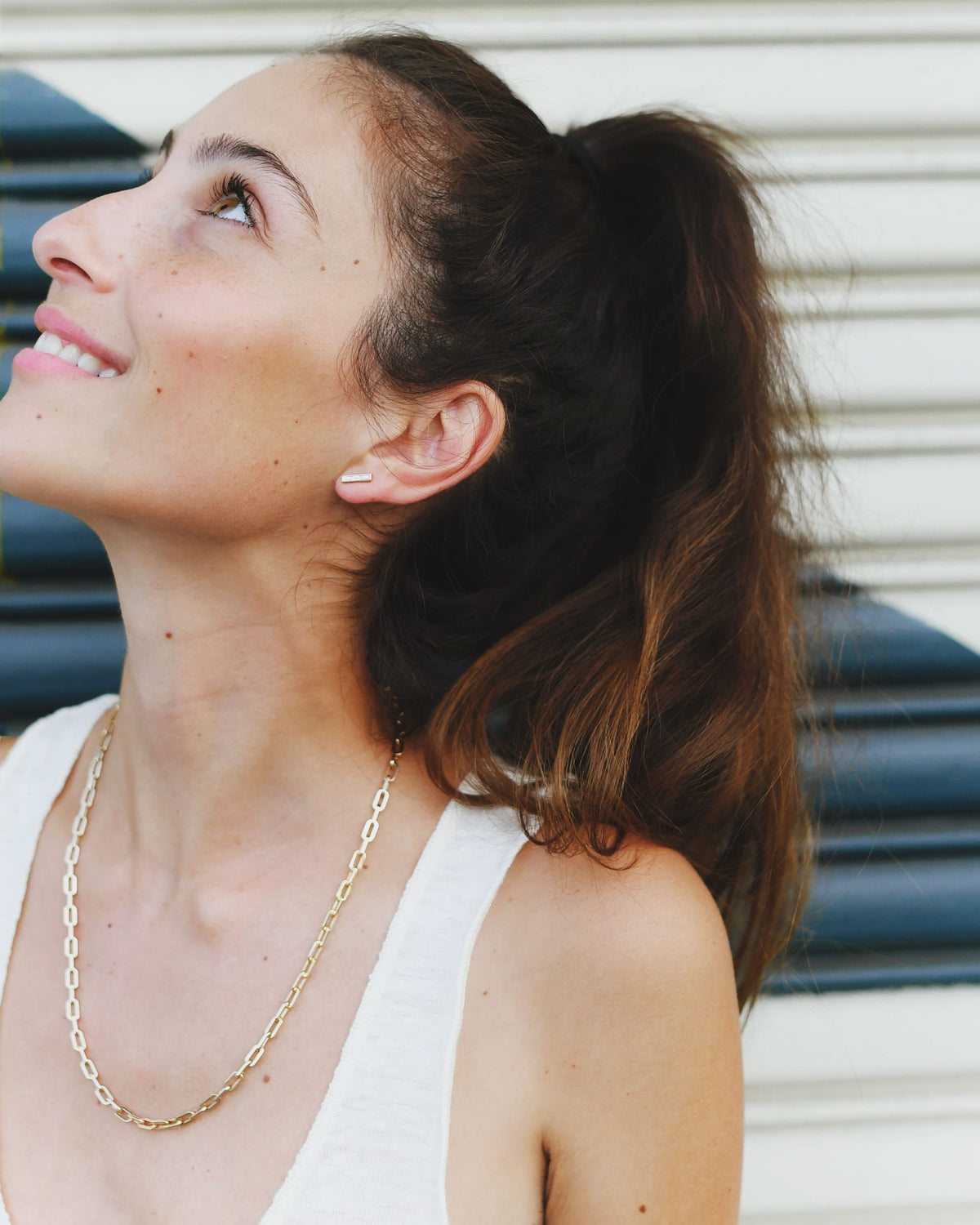 Classic Link Necklace on a smiling model in a white tank, her face turned up and hair in a high ponytail.