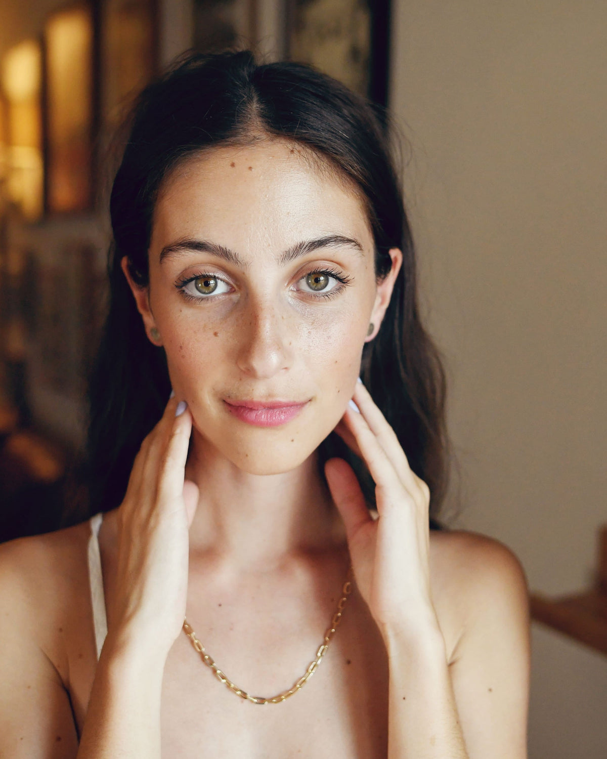 Classic Link Necklace on a model in a white camisole, her fingertips framing her jaw.