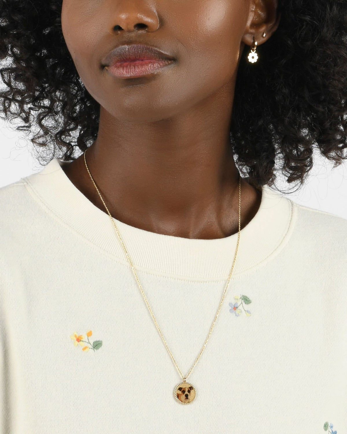 Imperial Portrait Pendant with a dog portrait on a model in a cream embroidered sweatshirt.