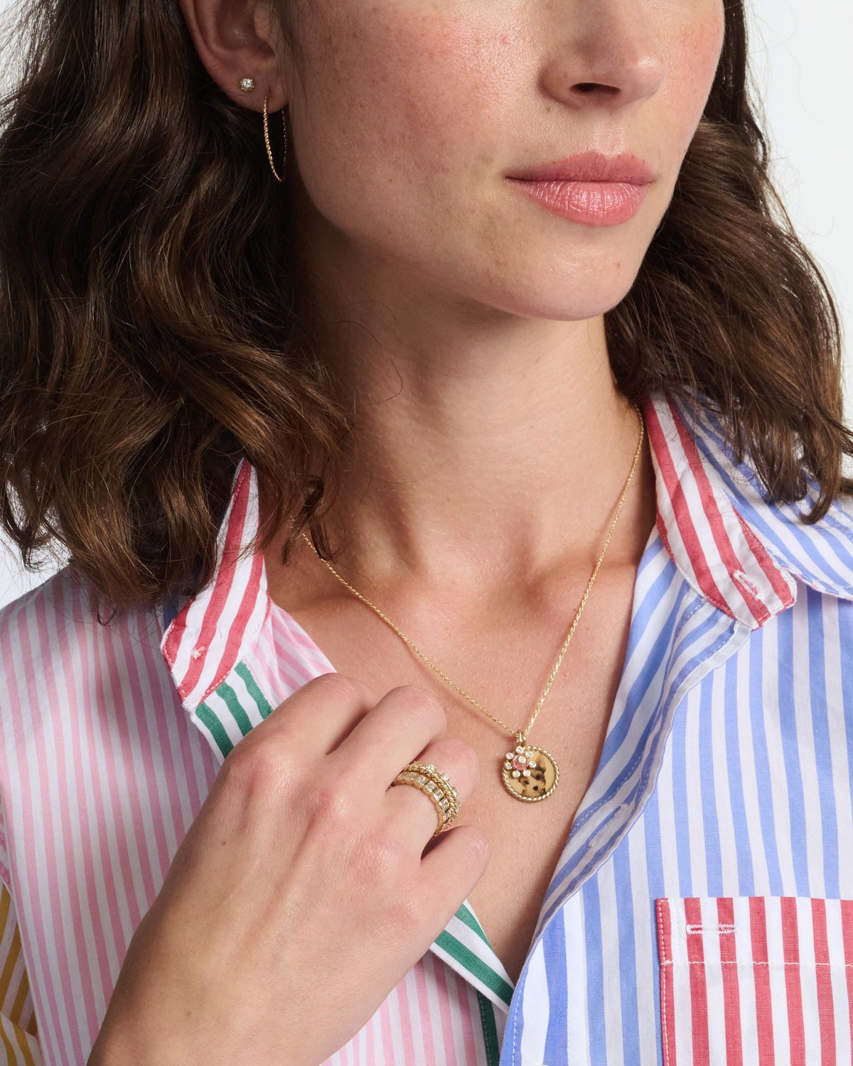 Imperial Portrait Pendant on a model in a multi-striped button-down, her hand resting near the pendant.
