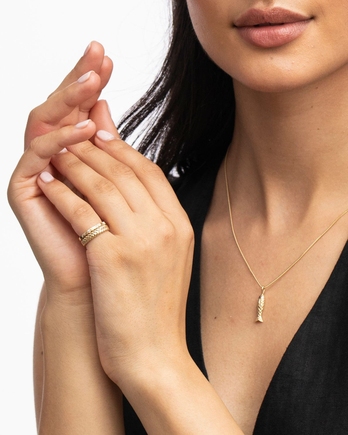 Poisson Pendant worn with a black vest, hands raised.