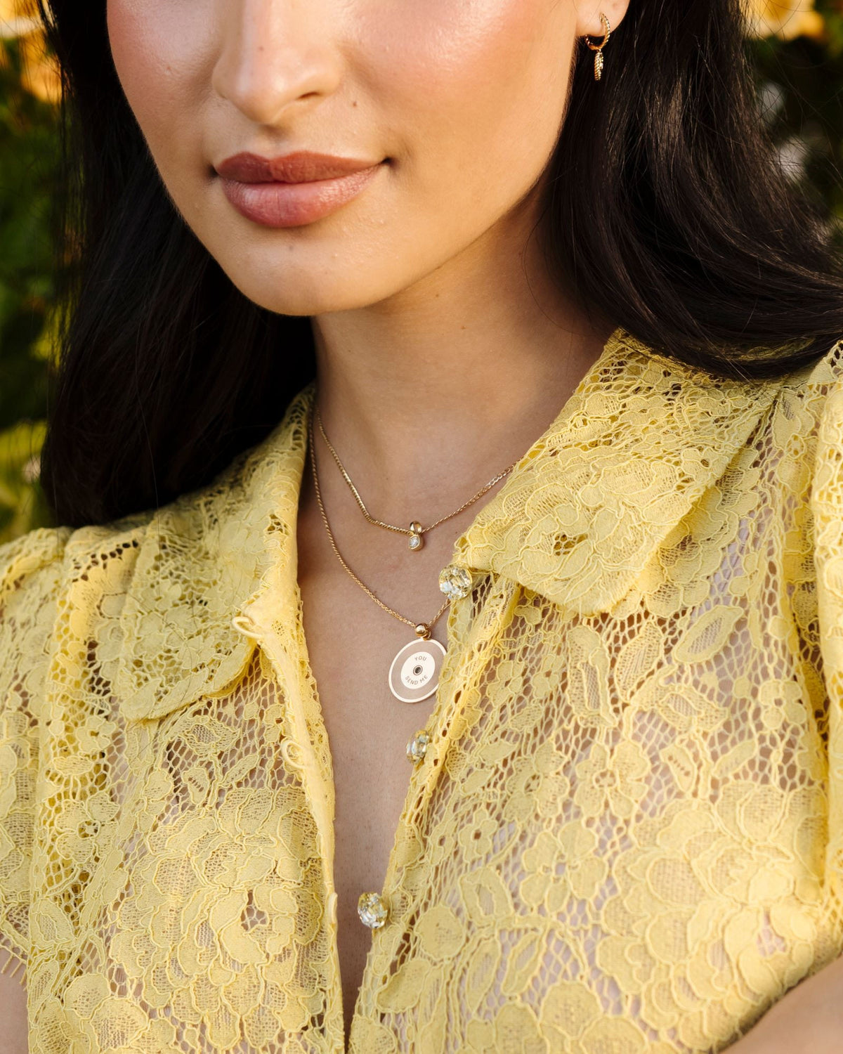 Grande Diamond Ace Pendant layered with a coin pendant over a yellow lace blouse.