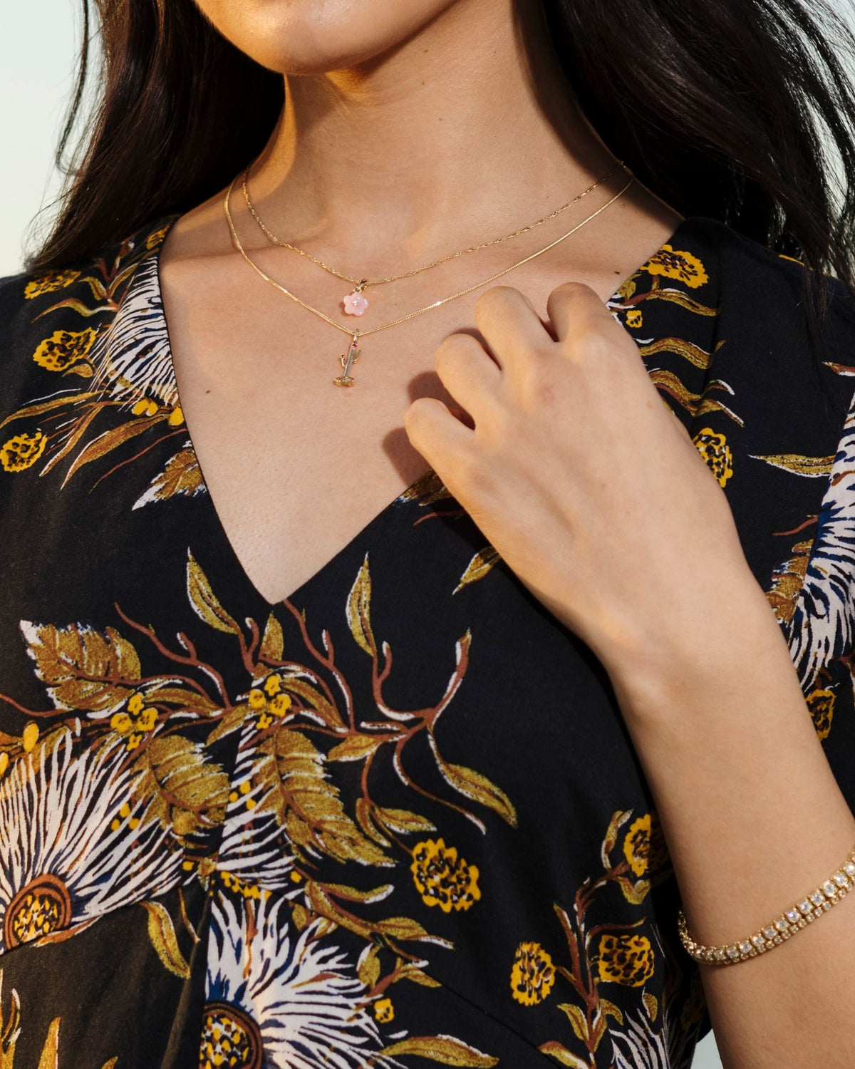 Diamond Blossom Peruvian Opal Charm worn with a black floral dress by the water.