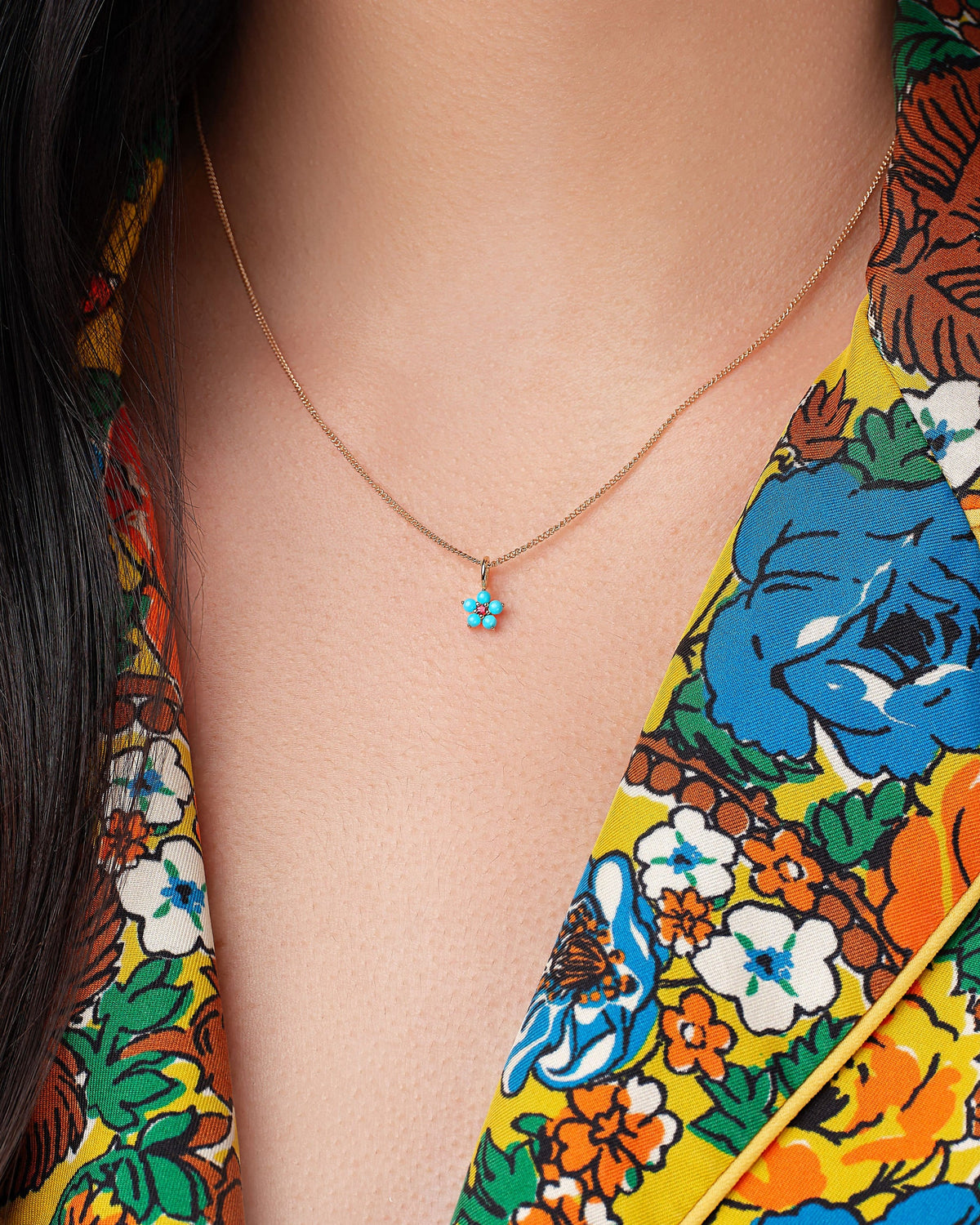 Turquoise and Tourmaline Aurora Charm worn with a floral jacket.