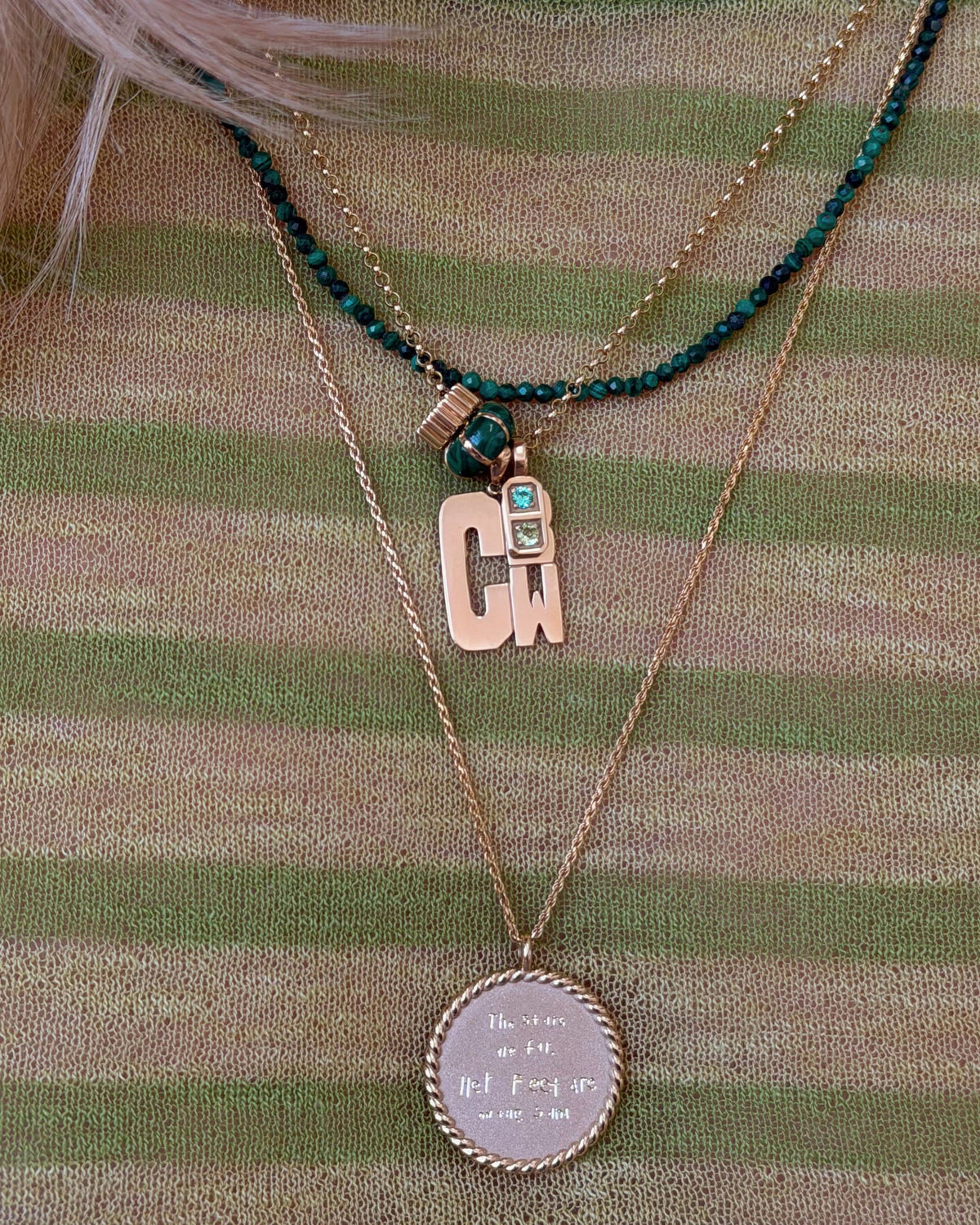 Petite Malachite Beaded Necklace with a monogram charm over a green striped top.
