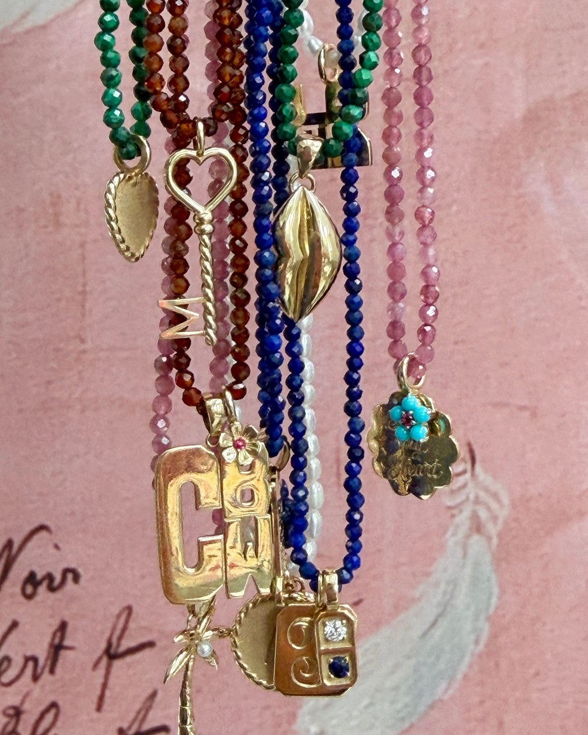 charms hanging on assorted petite beaded necklaces 
