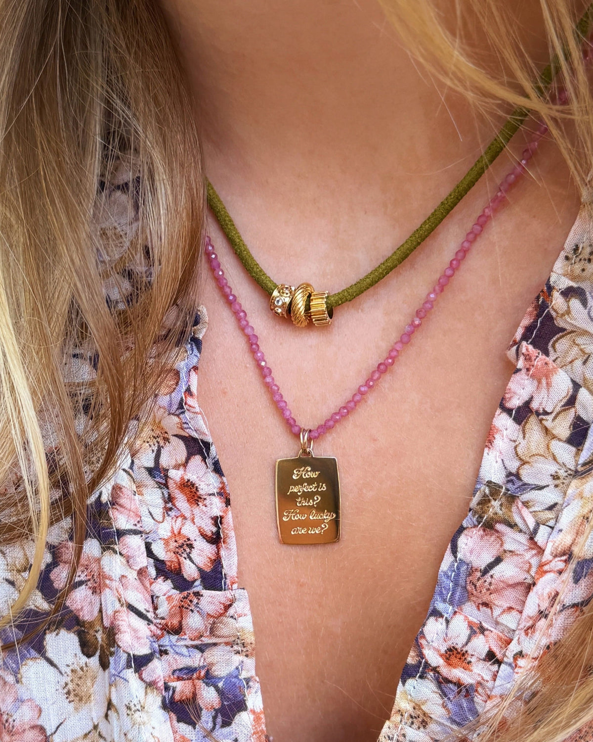 Petite Pink Tourmaline Beaded Necklace with an engraved tag over a floral blouse.