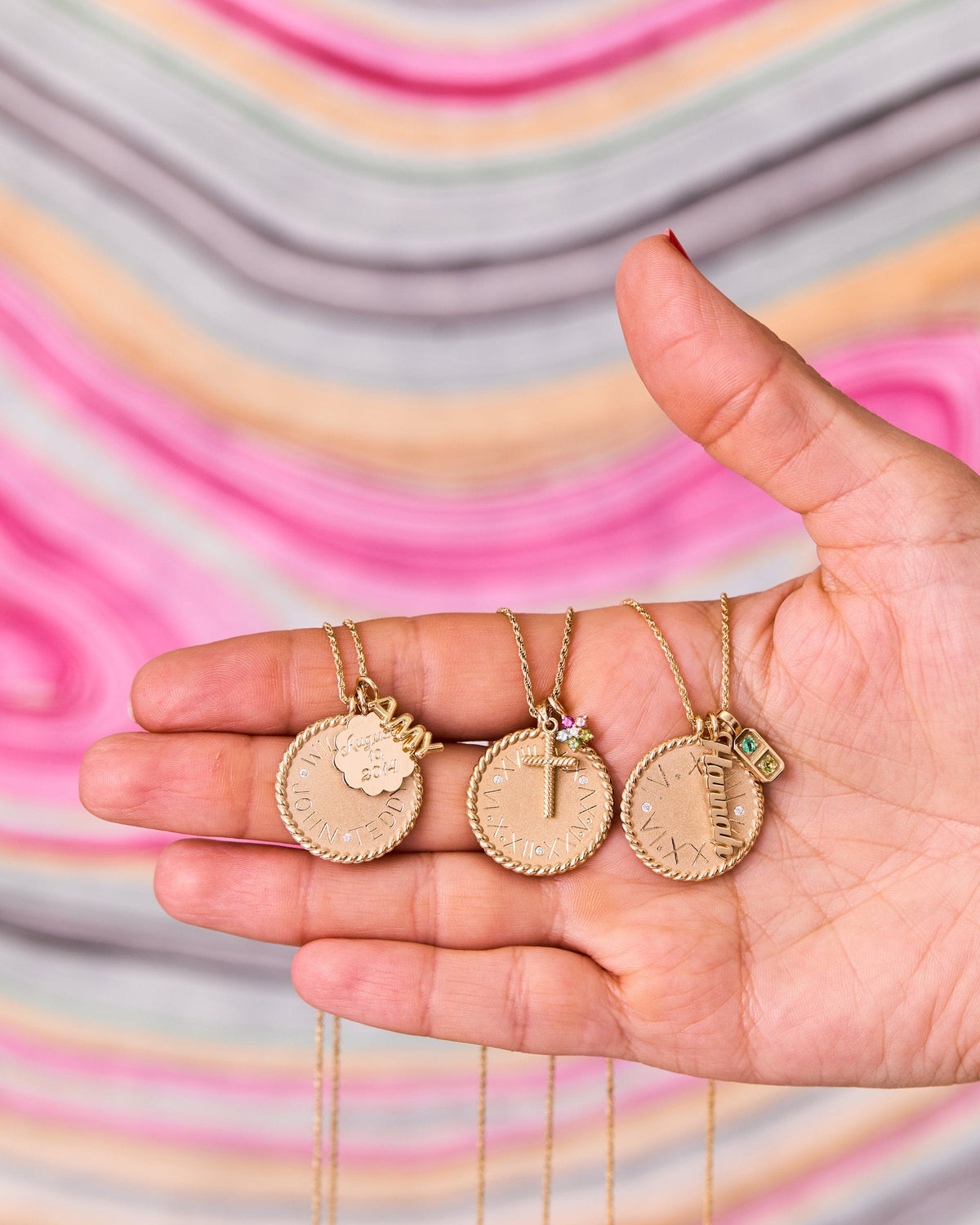 Personalized charms and Imperial Disc Pendants, with Script Name It Charm and Helium Name It Charm, stacked in hand