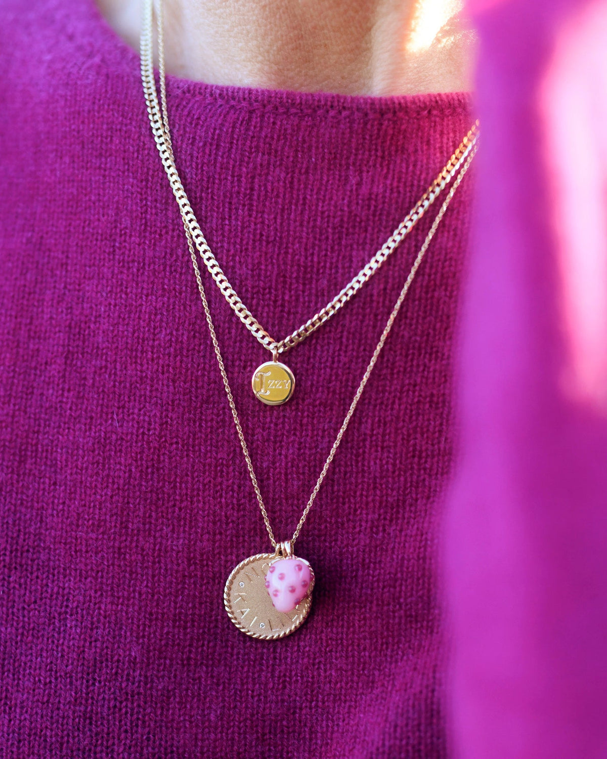 Model wearing pink sweater with Imperial Disc Pendant and strawberry charm